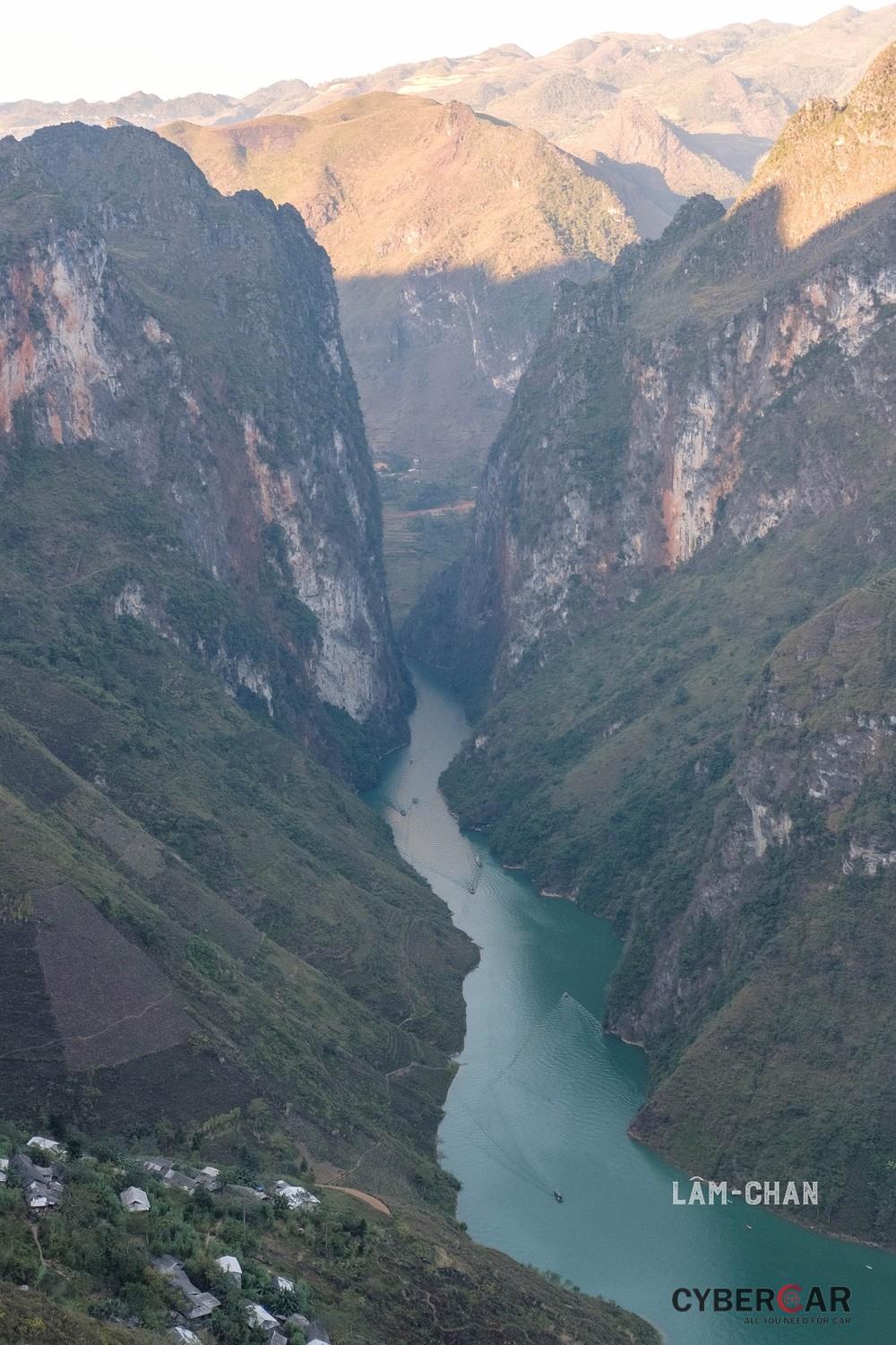 Dòng sông Nho Quế xanh mướt, dịu dàng chảy giữa 2 bên núi đá nguy nga, đồ sộ