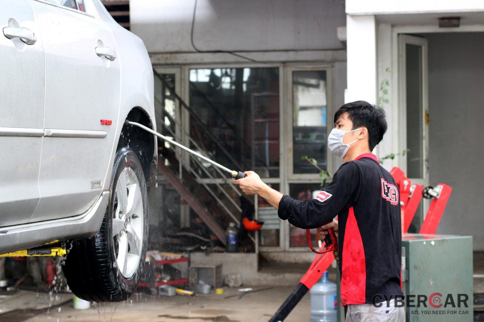 Rửa sạch gầm xe bằng vòi bơm cao áp.
